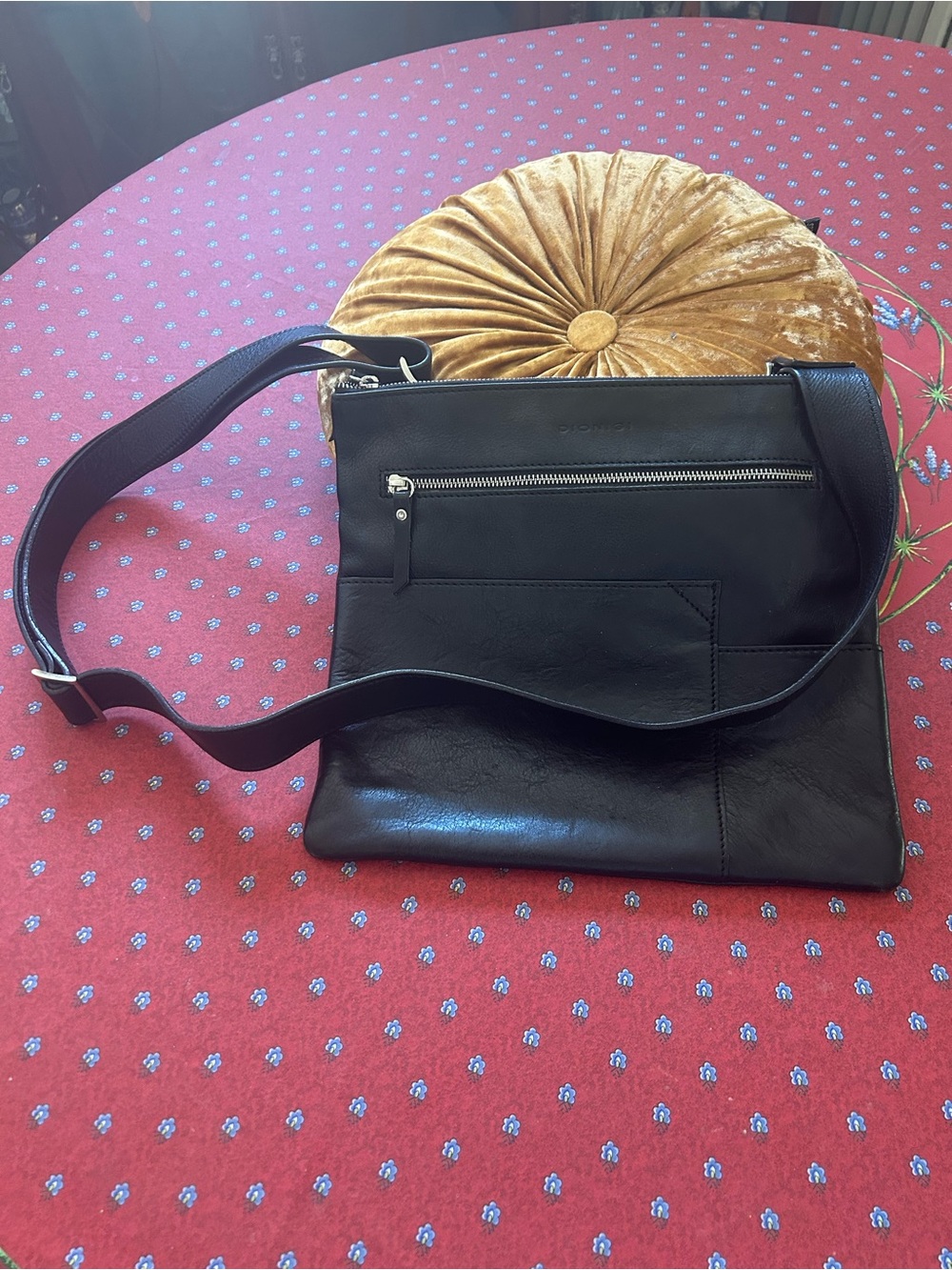 Black Leather Dionici Crossbody Bag with Front Zip Pocket and shoulder strap.